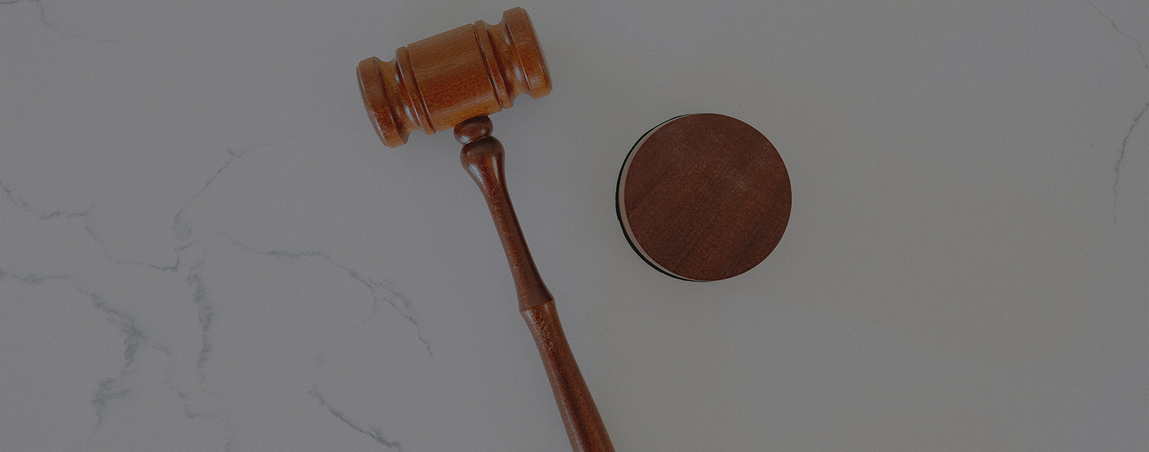 Wooden gavel on marble surface representing legal judgment